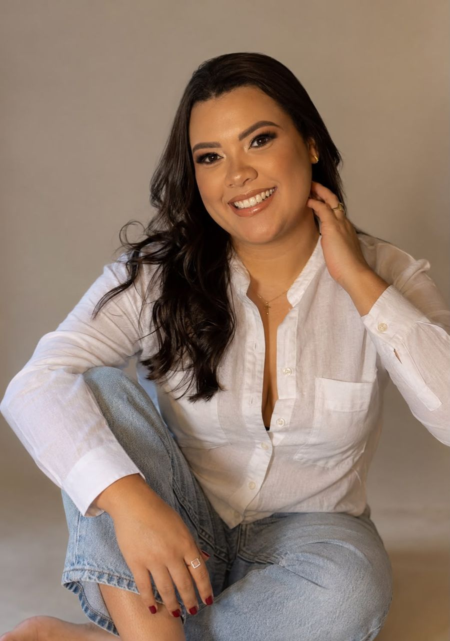 Thaís Fernandes, psicóloga, sorrindo, sentada